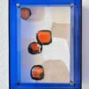 Abstraktes Mini-Kunstwerk mit orangen Formen im blauen Acrylglasrahmen, Titel: Upside